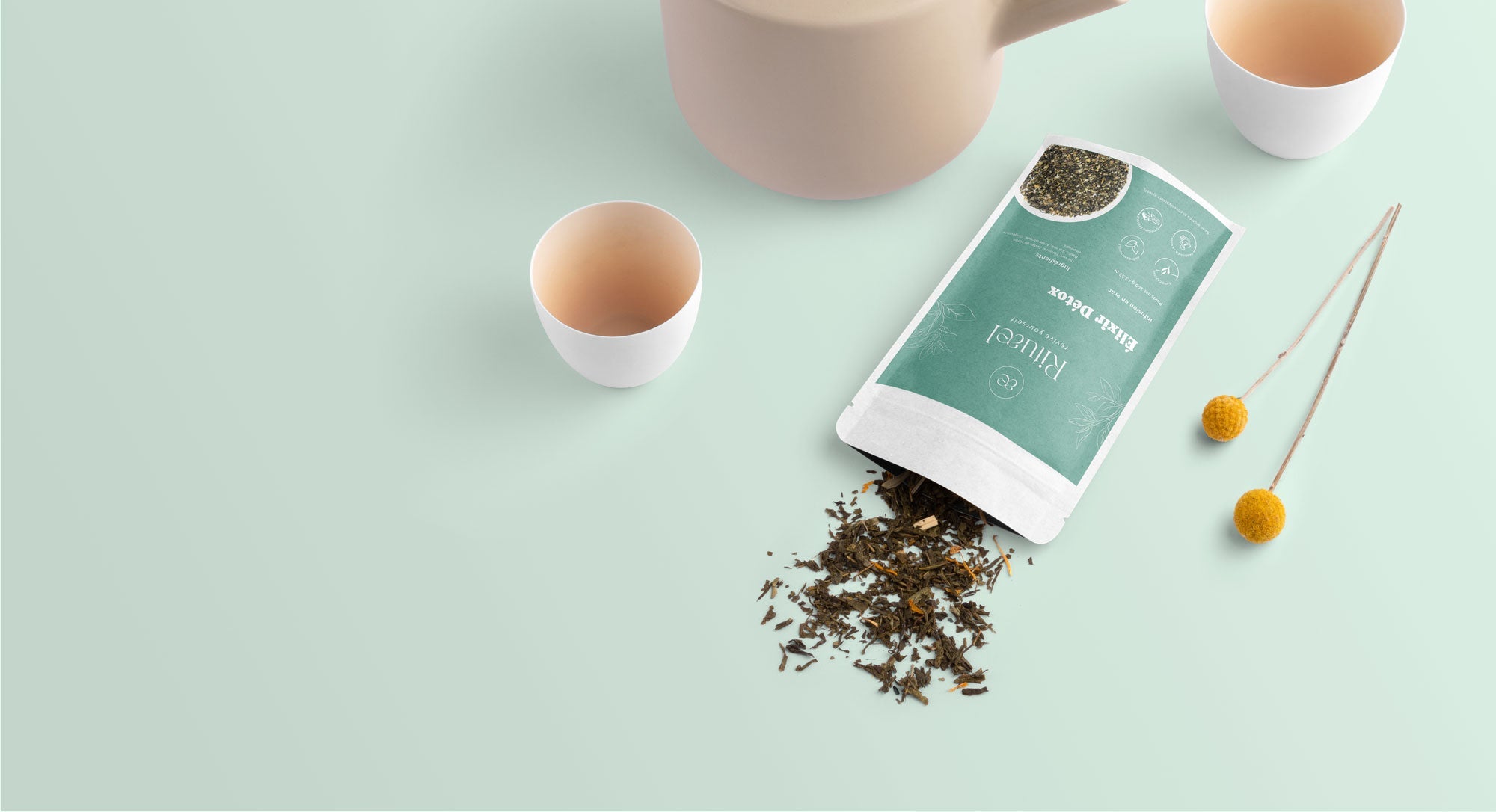 Tea packaging with loose tea leaves on a light green background